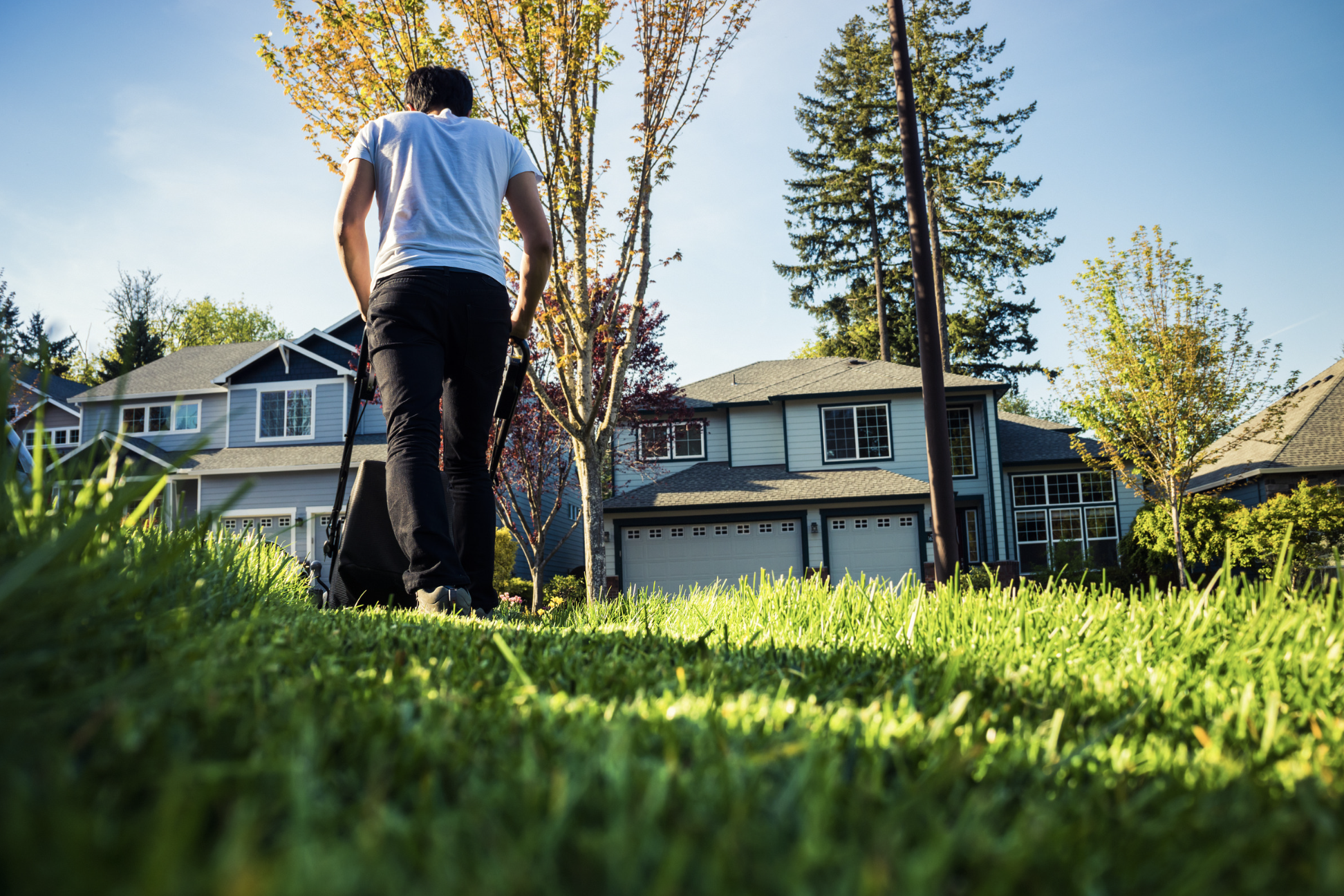 alabama lawn care tips by season, man mowing lawn